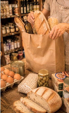 Bolsa con productos de alimentación, pan y conservas en tienda local
