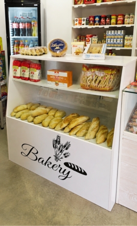 Bag containing food products, bread, and canned goods from a local shop.